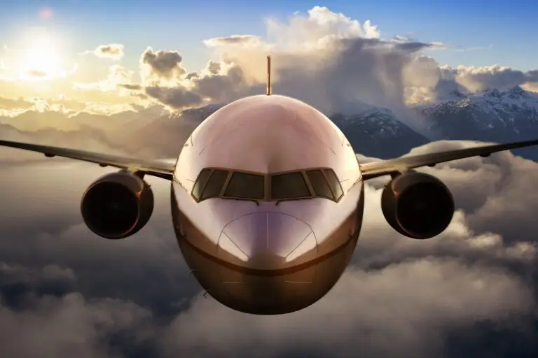 Airplane flying above the clouds during colorful sunset or sunrise. Concept of Travel